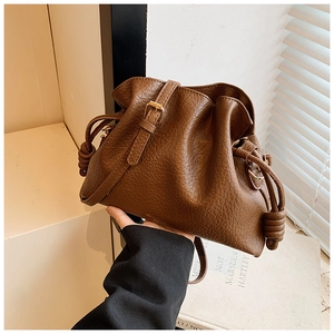 Detail of vintage brown pebble leather bucket bag with drawstring and knot detail