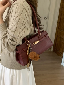 Chic burgundy shoulder bag with gold twist lock and cute plush dog charm accessory