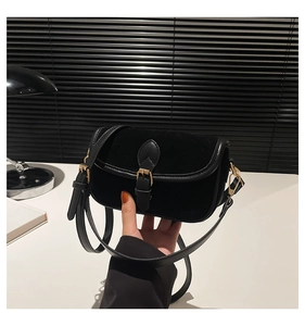 Detail of vintage square bag with black velvet flap and gold buckle closure