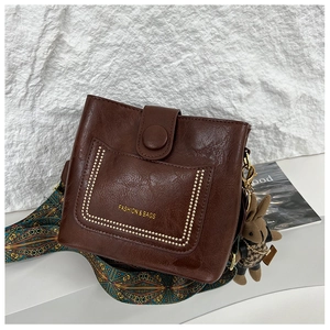 Detail of dark brown vintage oil wax leather bag with wide ethnic shoulder strap