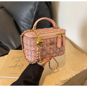 Detail of pink tweed handbag with gold metal ball adjuster and elegant chain strap