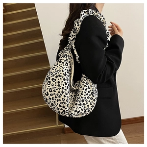 Detail of hobo bag featuring leopard print and pleated shoulder strap design