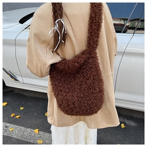 Detail of dark brown faux shearling crossbody bag with a plush curly texture and wide strap