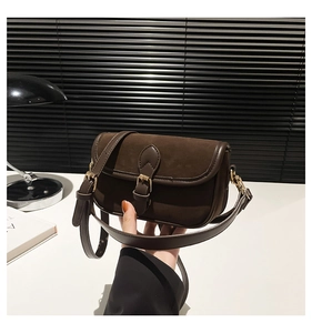 Detail shot of vintage brown square bag with suede flap and buckle closure
