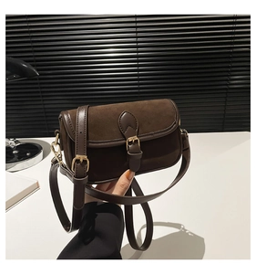 Detail of vintage dark brown crossbody bag featuring matte suede and smooth leather textures