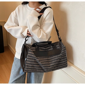 Detail of grey striped sports gym bag with leather handles and detachable shoulder strap