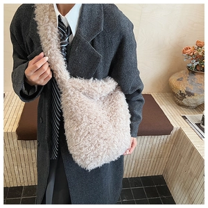 Detail view of beige lamb wool shoulder bag textured plush material on a model
