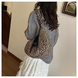 Detail of trendy leopard print tote bag featuring a decorative ruffled shoulder strap design