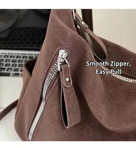 Close-up of the vintage brown leather tote bag showing smooth silver metal zipper detail