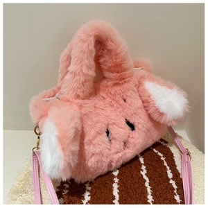 Close-up of pink fluffy rabbit plush bag with soft texture and golden metal hooks
