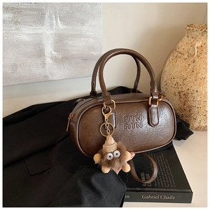 Detail shot of a brown vintage Boston bag with ATN logo and a plush monster charm