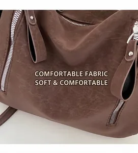 Detail shot of vintage brown tote bag showing soft leather texture and silver zipper