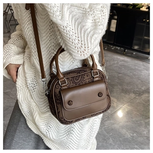 Close-up of retro mixed-material handbag with floral patterns and leather straps