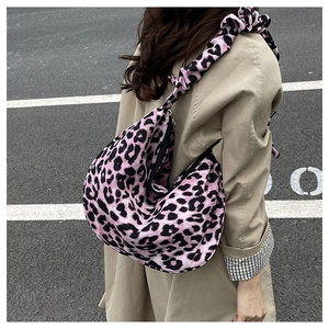 Detail of leopard print tote bag featuring a black zipper and ruffled cloud-style shoulder strap