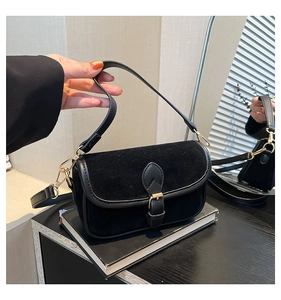 Detailed close-up of retro black square bag featuring matte suede and leather textures