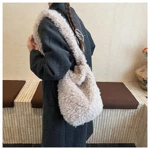 Close-up of fluffy beige faux shearling shoulder bag showing soft curly texture and large size