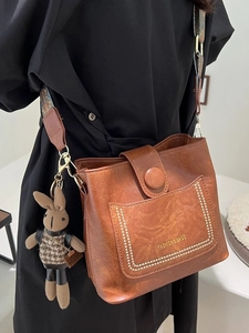 Vintage caramel brown bucket bag with jacquard strap and cute bunny pendant charm