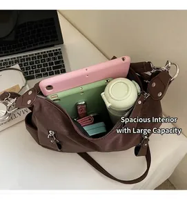 Detailed view showing the spacious interior of the brown leather tote bag with tech items