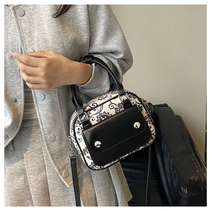 Detail of vintage floral canvas mini bag with leather trim and decorative silver studs