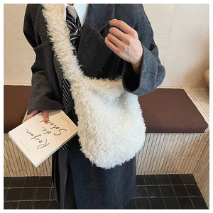 Detailed view of white faux shearling crossbody bag styled with a grey blazer outfit