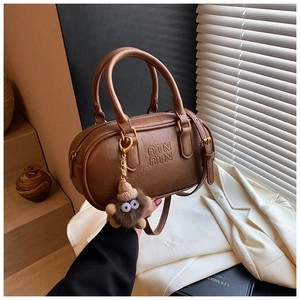 Detail of dark brown leather bowling bag with ATN embossed logo and plush charm