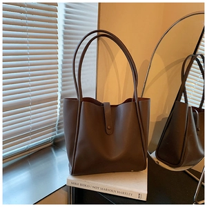 Détail du sac cabas en cuir mat marron foncé avec fines bretelles et fermeture à pression