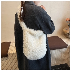 Close-up of fluffy white faux fur crossbody bag shown in a cozy cafe setting