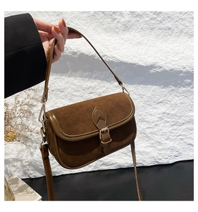 Detail of a brown vintage square shoulder bag featuring suede texture and metal buckle
