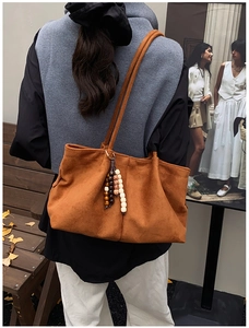 Gros plan d'un grand sac cabas marron en daim avec perles décoratives style automne