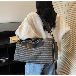 Detail of striped travel bag featuring side zipper shoe compartment and black handles