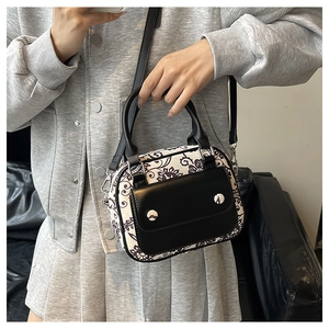 Detail of vintage floral pattern and textured faux leather on the crossbody handbag