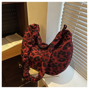 Detail of red and black leopard print hobo bag in soft canvas fabric with knotted strap