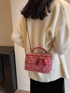 Pink tweed mini box handbag with red leather handle and golden camellia buckle shown on model