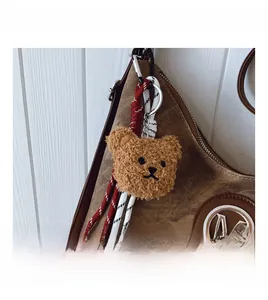 Gros plan d'un charm ours en peluche marron avec corde tressée sur un sac cabas