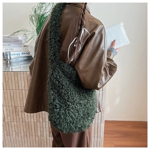 Detail of dark green plush tote bag featuring soft grainy texture and wide shoulder strap