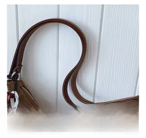 Détail des poignées en cuir synthétique marron et de la fermeture éclair du sac cabas