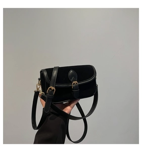 Detail of vintage black velvet small square bag with leather trim and gold metal buckle