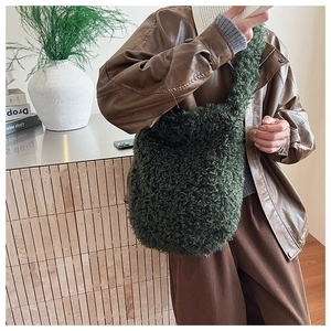 Close-up of a dark green curly plush tote bag showing detailed fleece texture