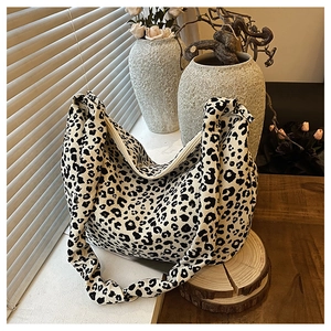 Detail of trendy leopard print tote bag with soft fabric texture and wide shoulder strap