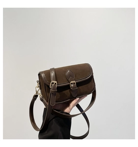 Detail shot of vintage brown suede crossbody bag with premium glossy PU leather trim