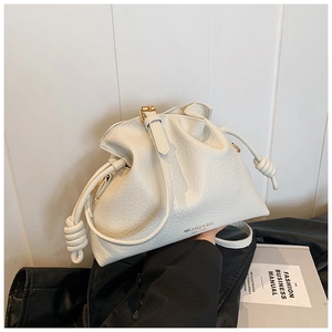 Detail of cream-colored pebble leather bucket bag with drawstring and brand logo