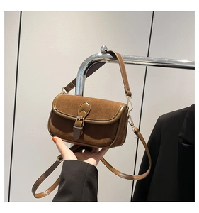 Detailed view of vintage brown suede and leather patchwork bag with buckle closure