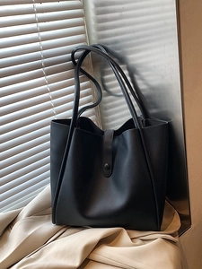 Sac fourre-tout élégant en cuir noir avec doubles bandoulières sur fond texturé neutre