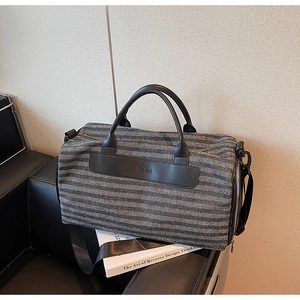 Close-up of striped travel bag with premium leather details and Noco Bag logo