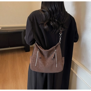 Detail view of vintage dark brown tote bag with twin silver zippers and side pockets on model