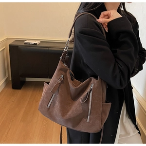 Brown vintage tote bag with metal zipper details worn by model for casual commute
