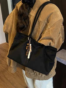 Sac fourre-tout noir tendance avec pompon en perles de bois porté pour le style d'automne