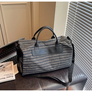 Detail of striped travel bag featuring a wet pocket, shoe compartment and leather handles