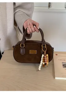 Détails du sac Boston en daim marron avec gland en perles et plaque dorée élégante