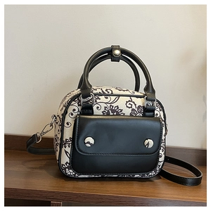 Detail of vintage floral print boston bag with black leather front pocket and top handles
